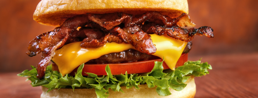 *** Local Caption *** Bacon burger with beef patty on red wooden table