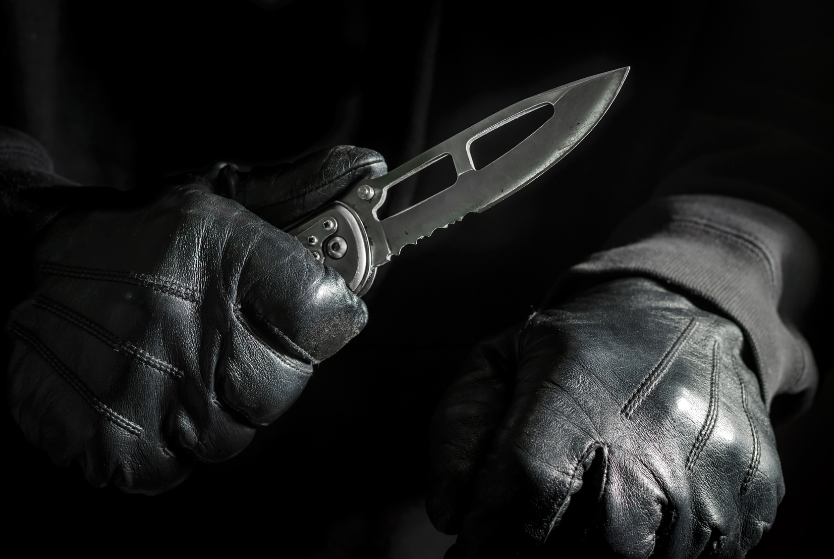 Assassin Holding Knife with Black Leather Gloves