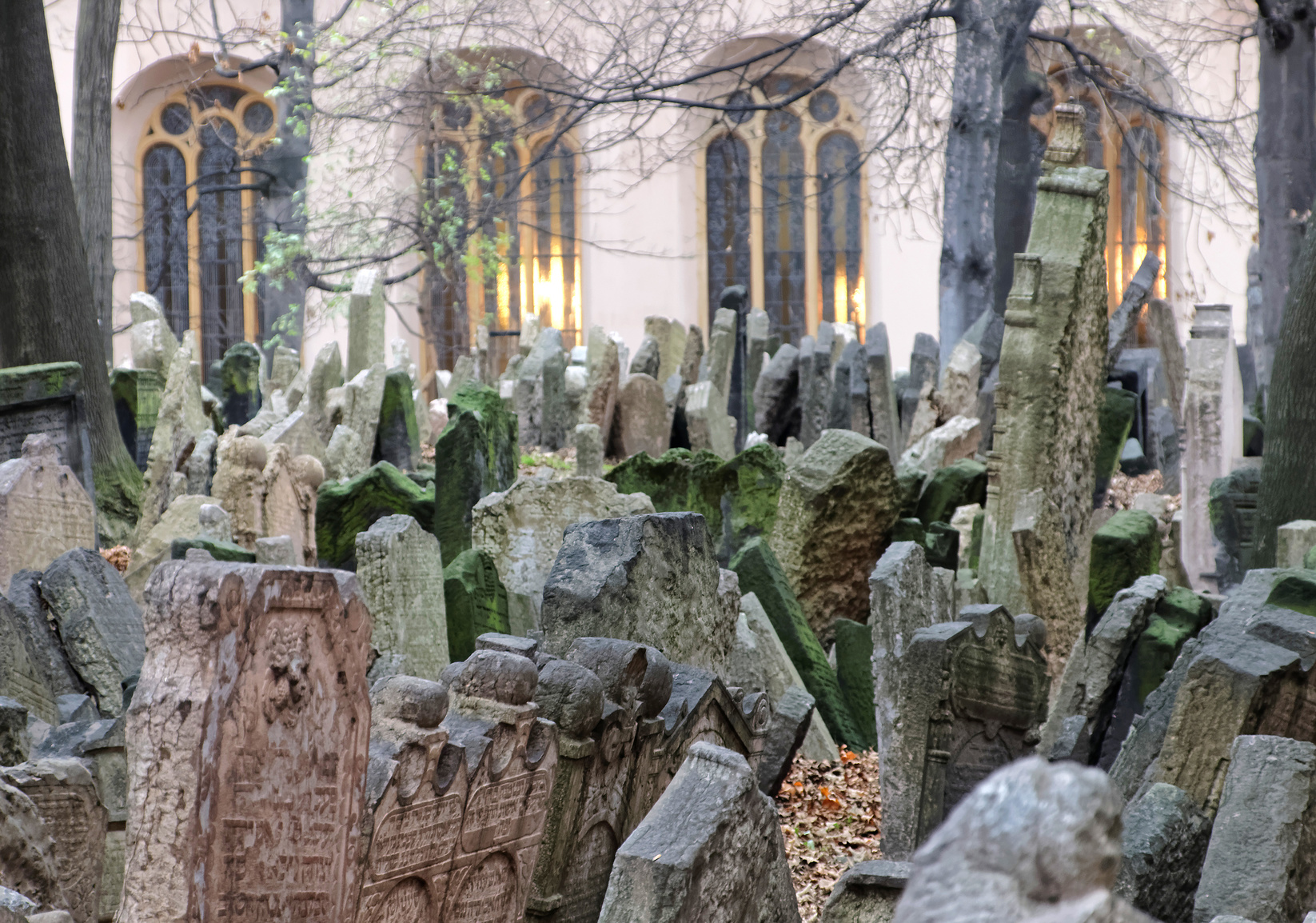 PRAGUE, CZECHIA - DEC 04, 2015: Old Jewish cemetery with lots of ancient headstones and a church in the background. December 04, 2015 in Prague, Czechia