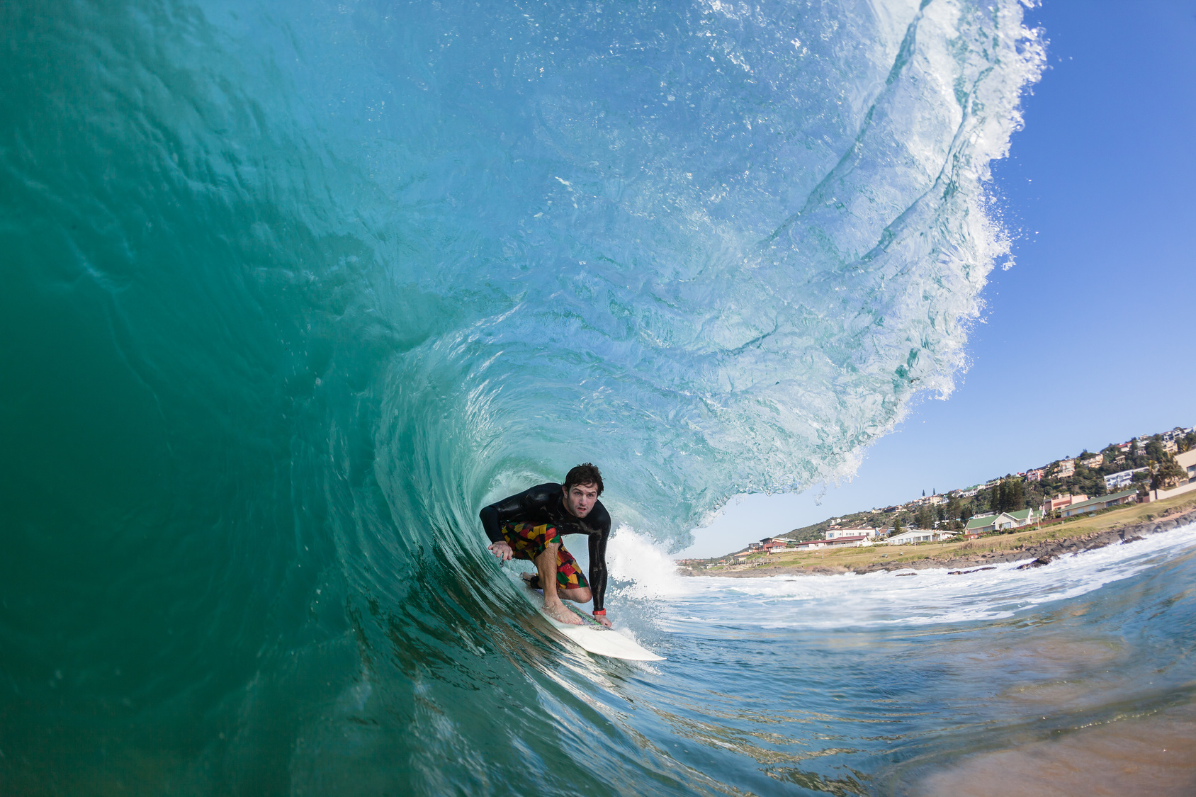 Surfer rides hollow blue ocean wave tube ride , closeup water photo