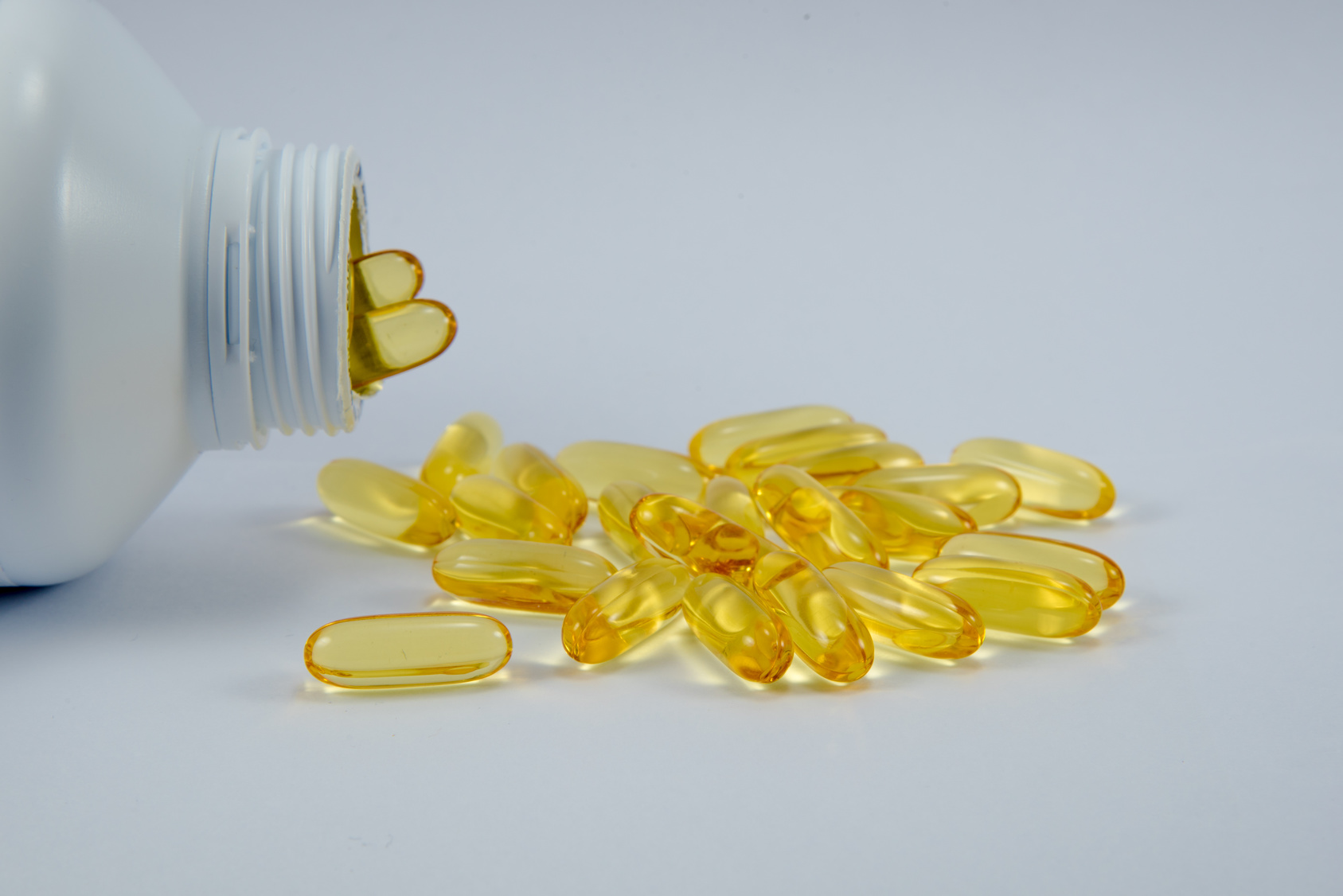 fishoil capsules from bottle in white background