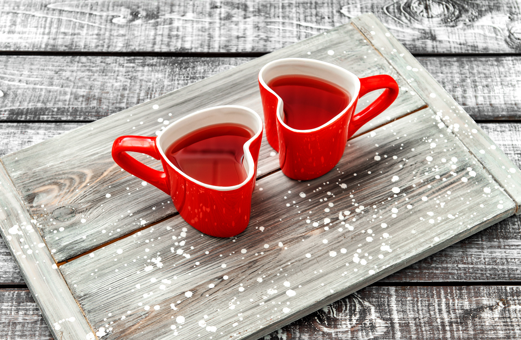 Heart shaped cups with red drink on rustic wooden background. Valentines day concept