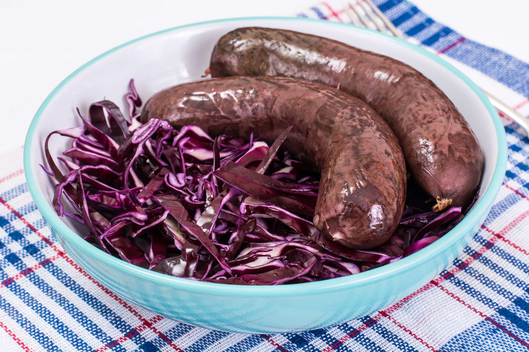 Homemade blood sausage with cabbage on a white background. Studio Photo