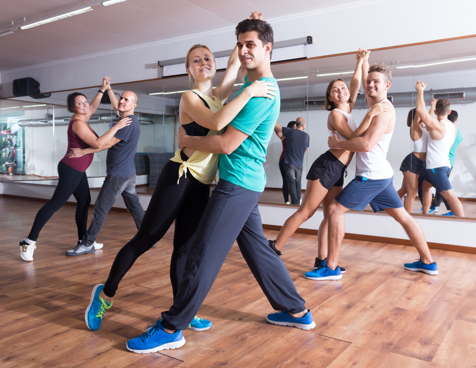 Friendly adults dancing bachata together in dance studio